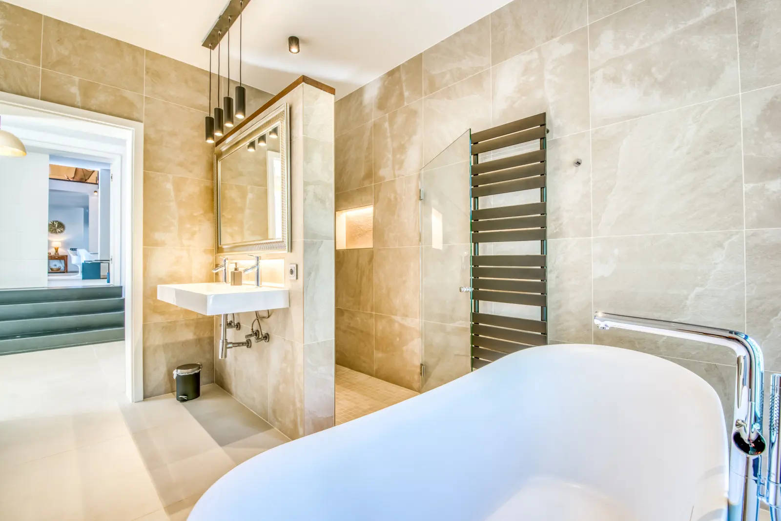 Bad en suite mit freistehender Wanne, Handtuchheizkörper und Dusche, Blick zur Ankleide