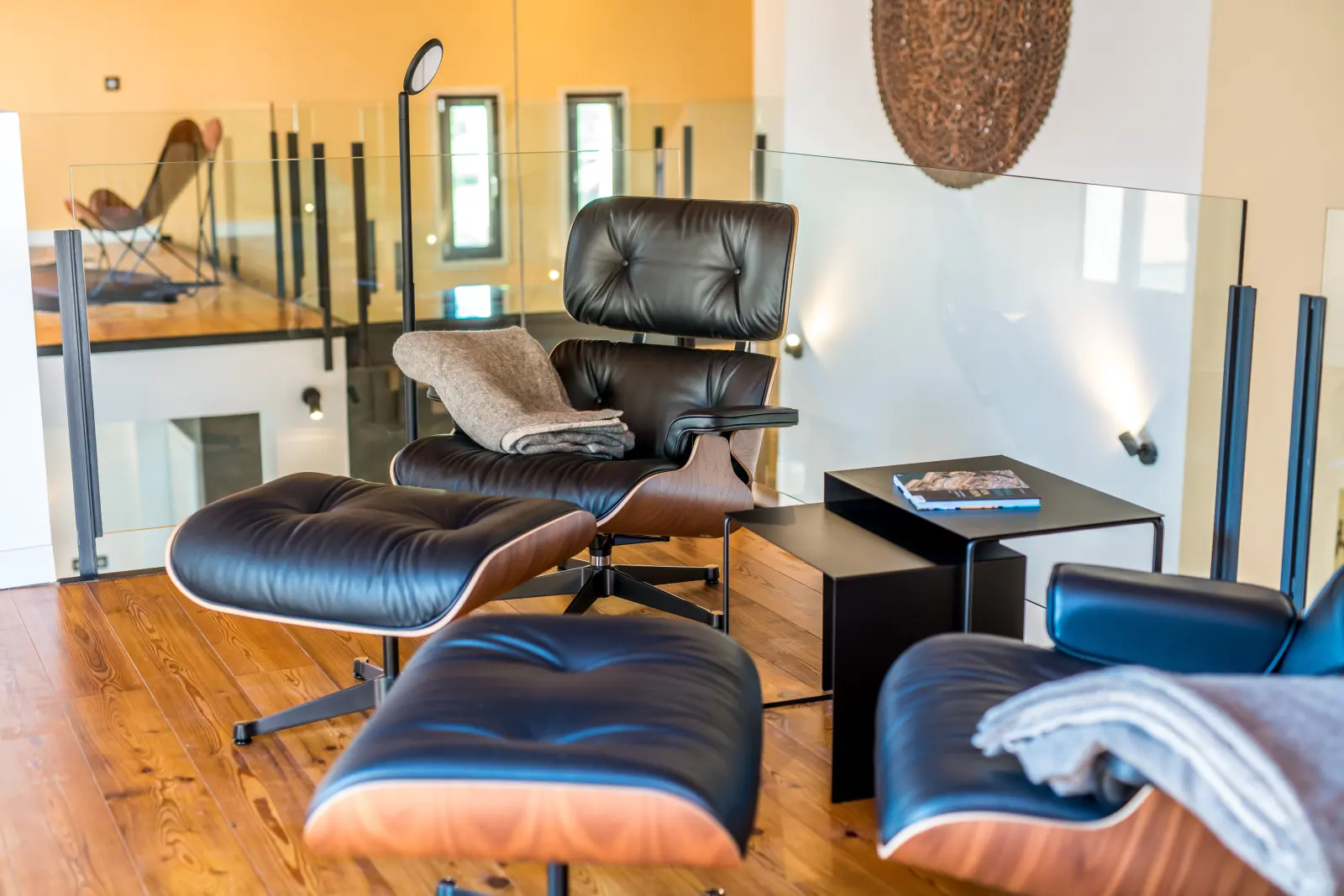 Eames Lounge Chair mit Ottomane auf der Galerie mit Glasbrüstung
