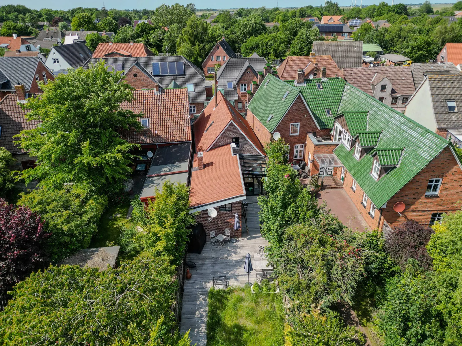 Luftbild des Stadthauses mit Garten zwischen Häusern mit grünen Dächern