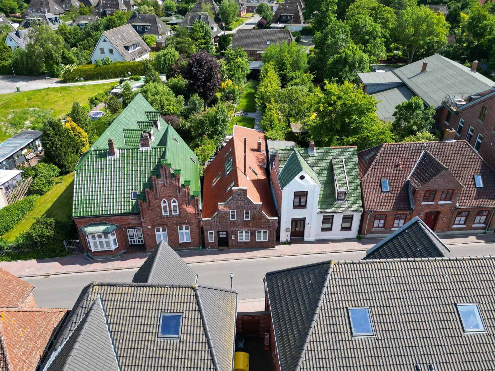 Drohnenaufnahme der Dorfstraße mit Backsteinhäusern und grünen Dächern