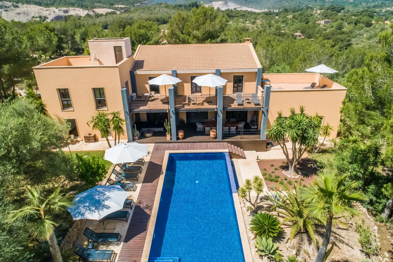 Drohnenansicht der Finca mit langem Pool und Terrassen zwischen Palmen