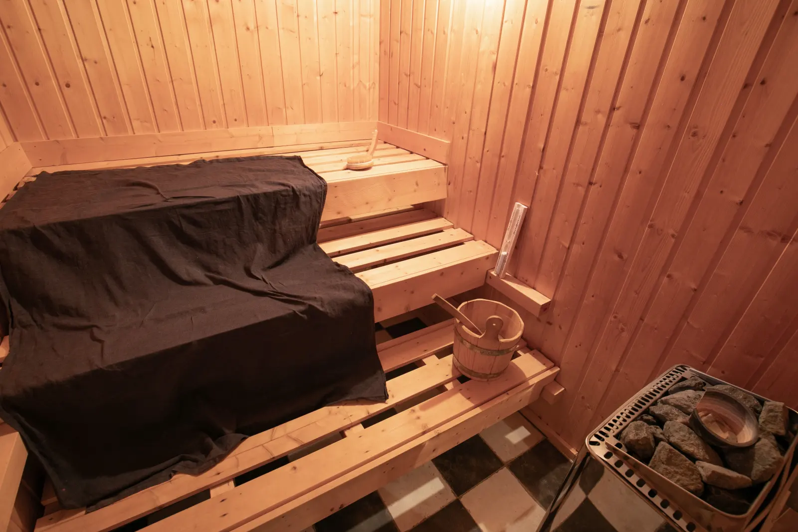 Saunakabine aus Holz mit Saunaofen und Eimer