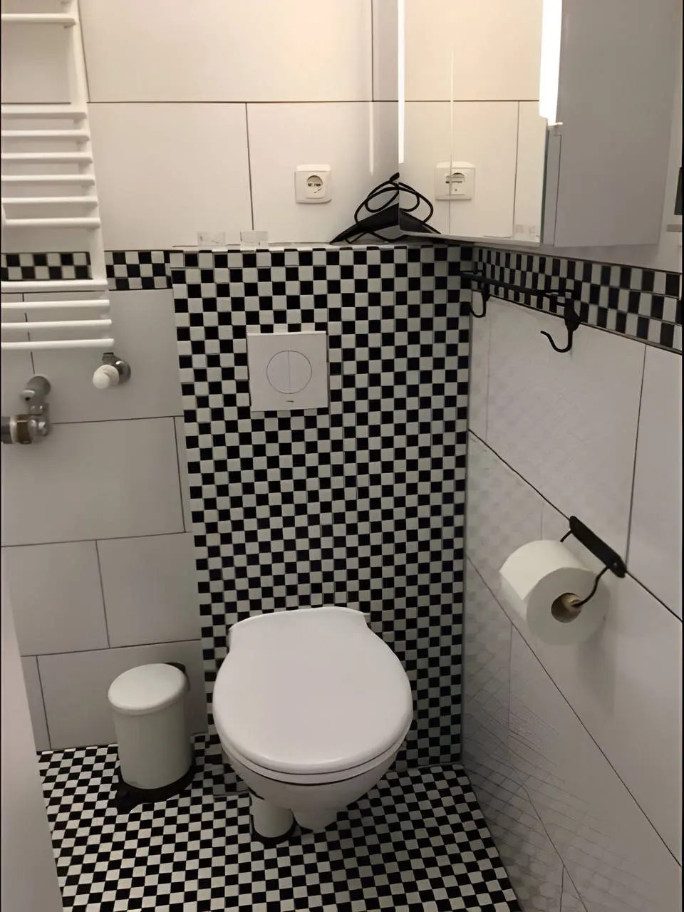 Gäste-WC mit schwarz-weißem Schachbrettmuster und Wand-WC