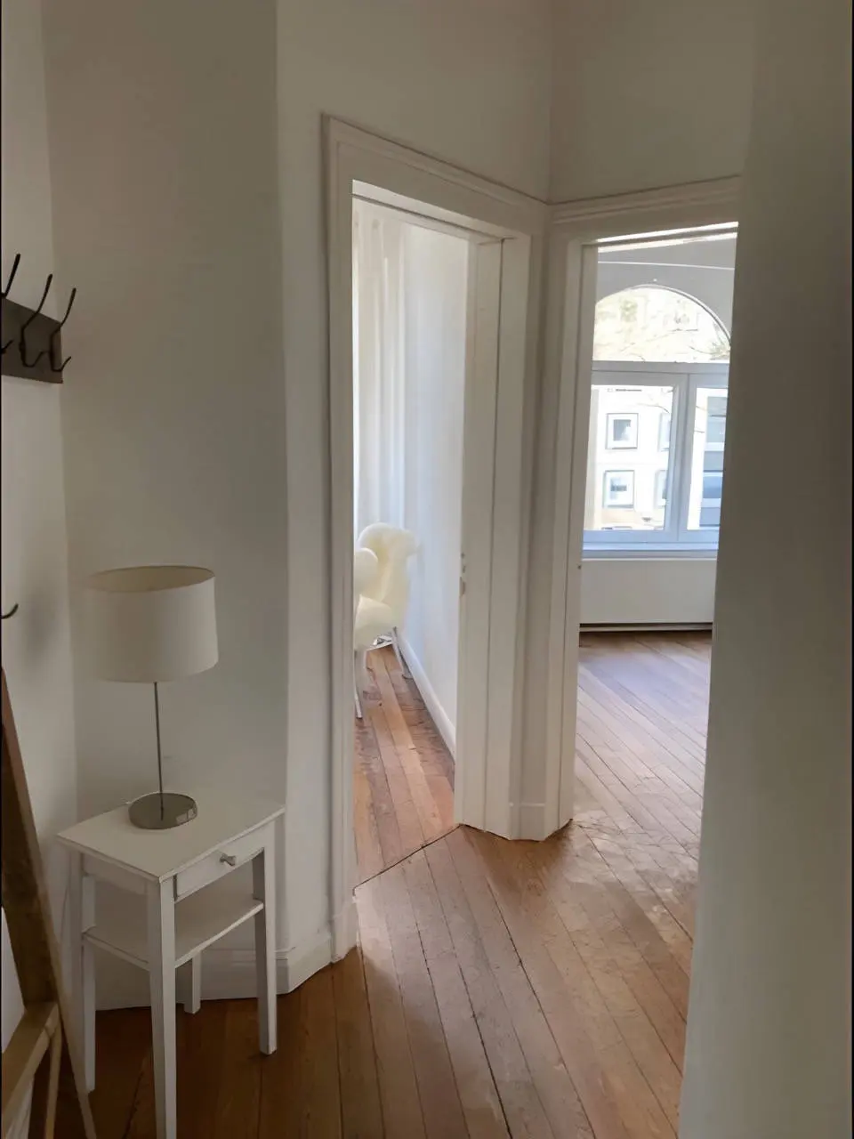 Flur mit Tischlampe und Durchblick in die Räume der Altbauwohnung
