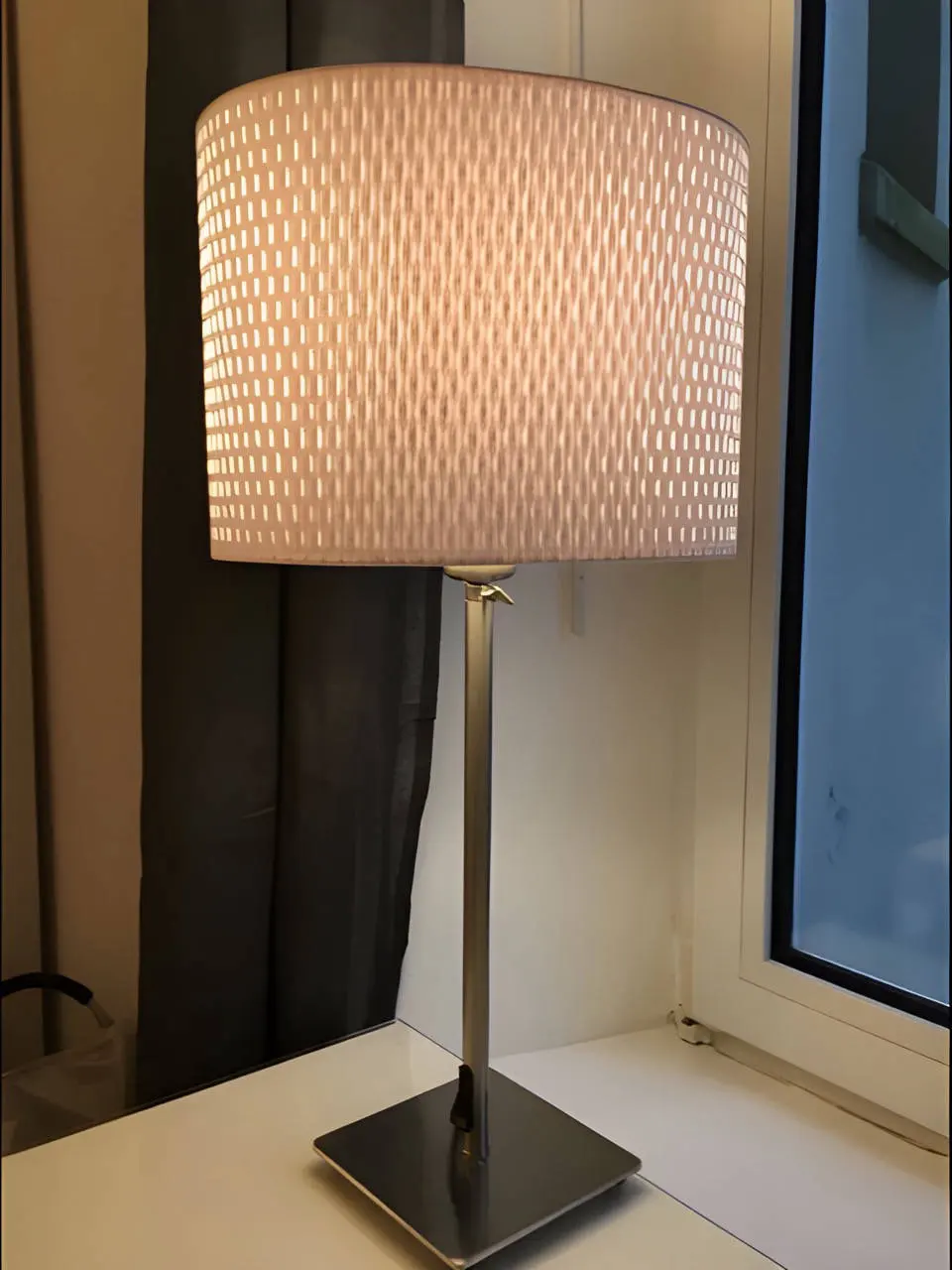 Tischlampe mit hellem Schirm auf dem Schreibtisch am Fenster