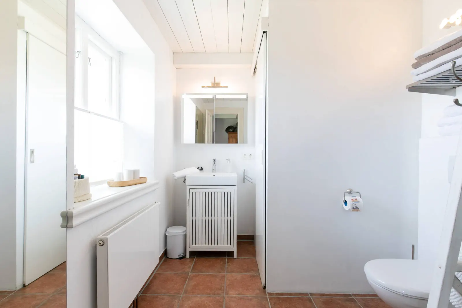 Gästebad mit Waschtisch, Wand-WC und Terrakottafliesen
