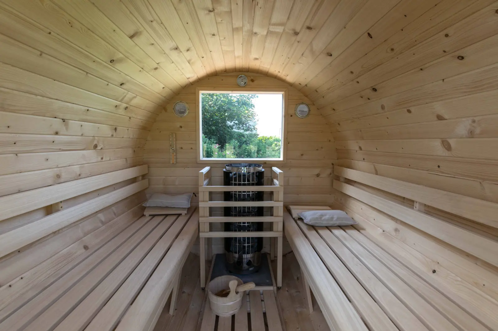 Saunakabine aus Holz mit zwei Bänken, Ofen und Fenster