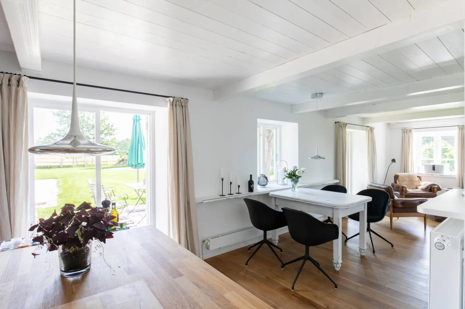 Esstisch am Terrassenfenster mit Vorhang und Blick auf den Garten