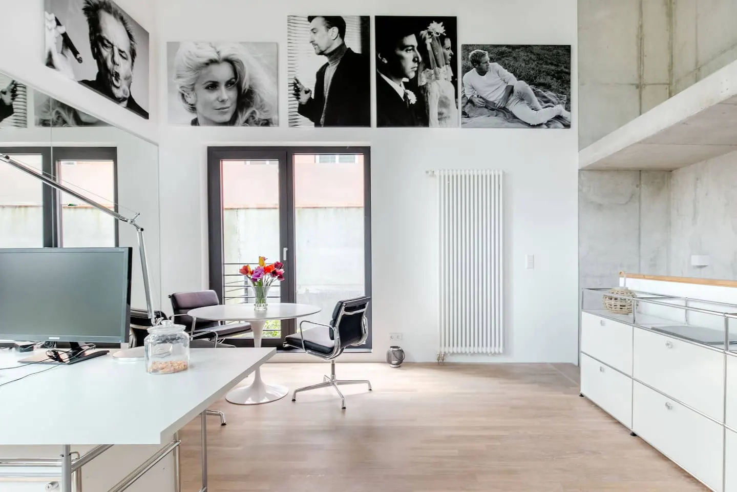Wohnraum des Lofts mit Arbeitstisch, Küchenzeile und Galerie mit Fotowand