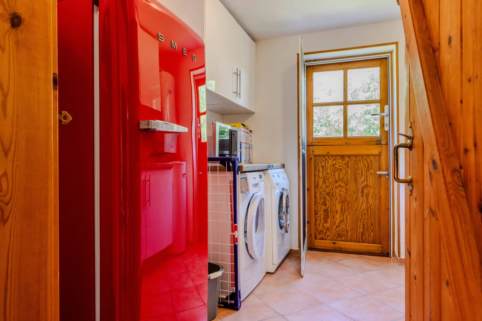 Hauswirtschaftsbereich mit Waschmaschine und Trockner neben der Holztür