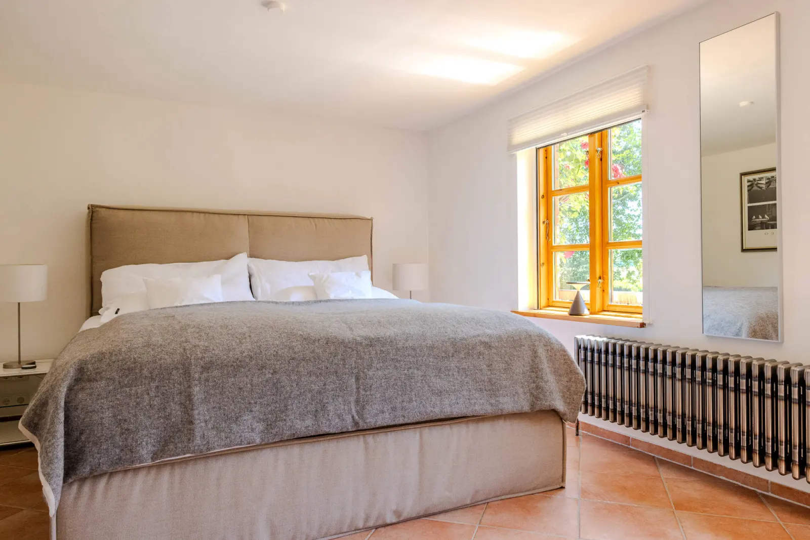 Doppelbett mit Polsterkopfteil und Spiegel im Erdgeschoss-Schlafzimmer