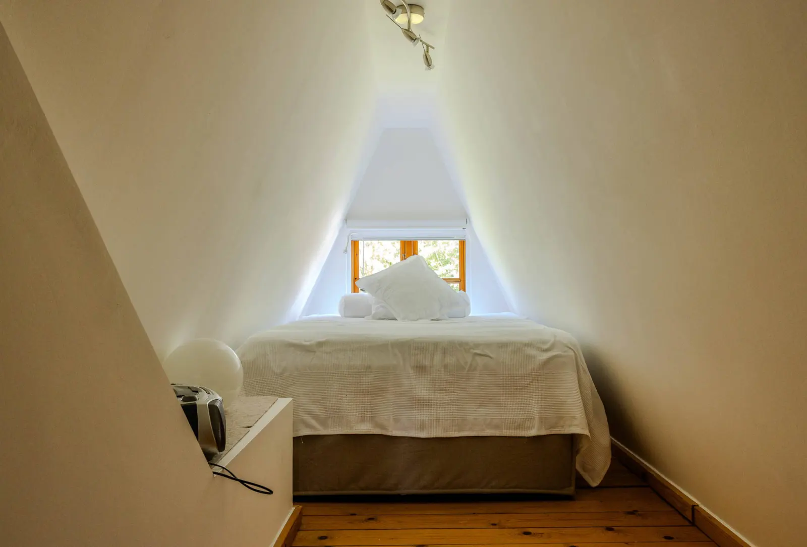 Kleines Gästebett in der Dachnische mit Giebelfenster
