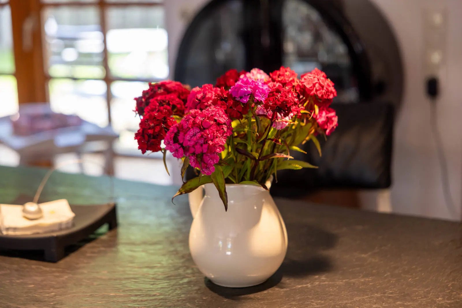Vase mit pinkfarbenen Nelken auf dem Tisch, Detailaufnahme