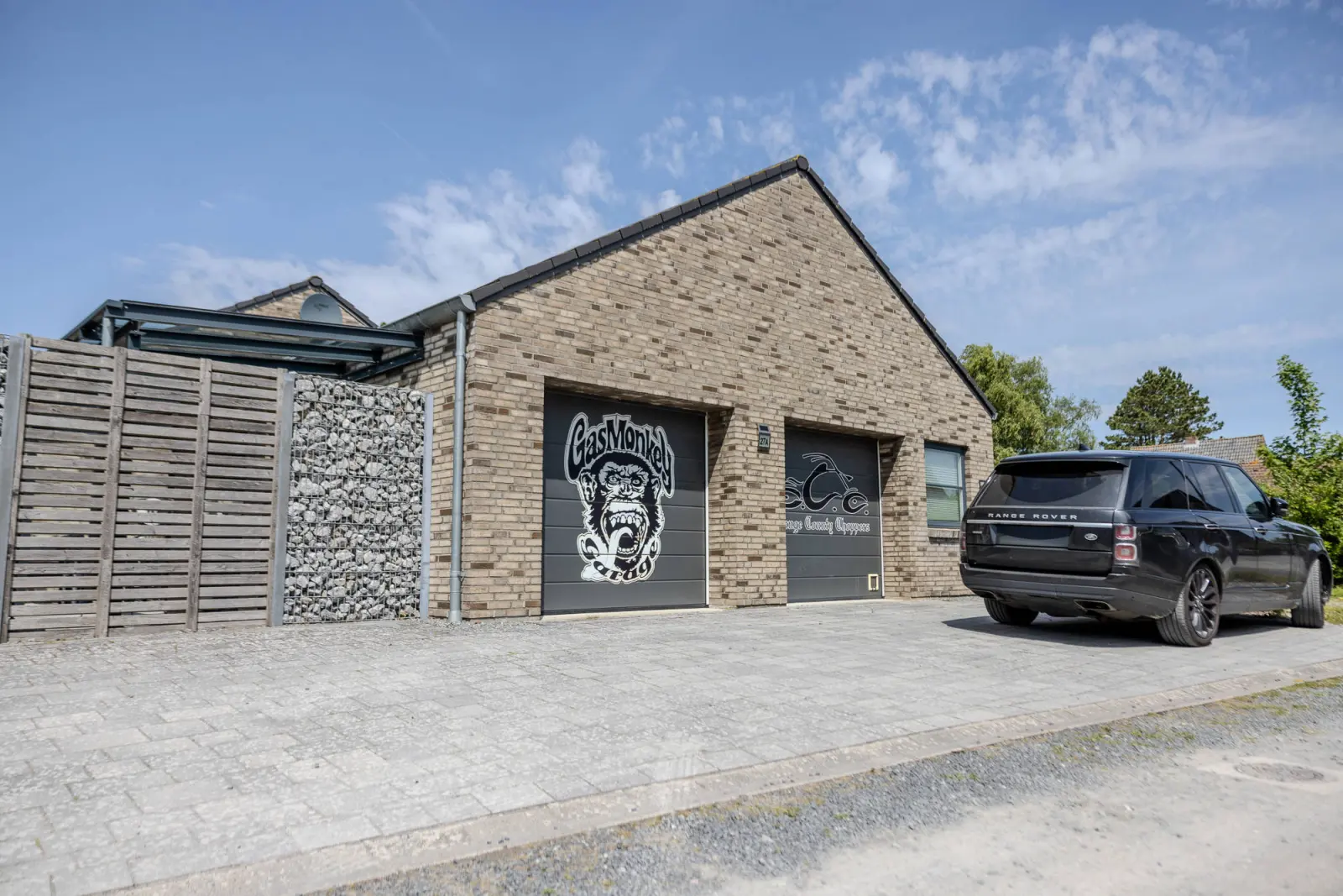 Klinkerhaus mit Doppelgarage, Garagentor mit Grafik und gepflasterter Auffahrt