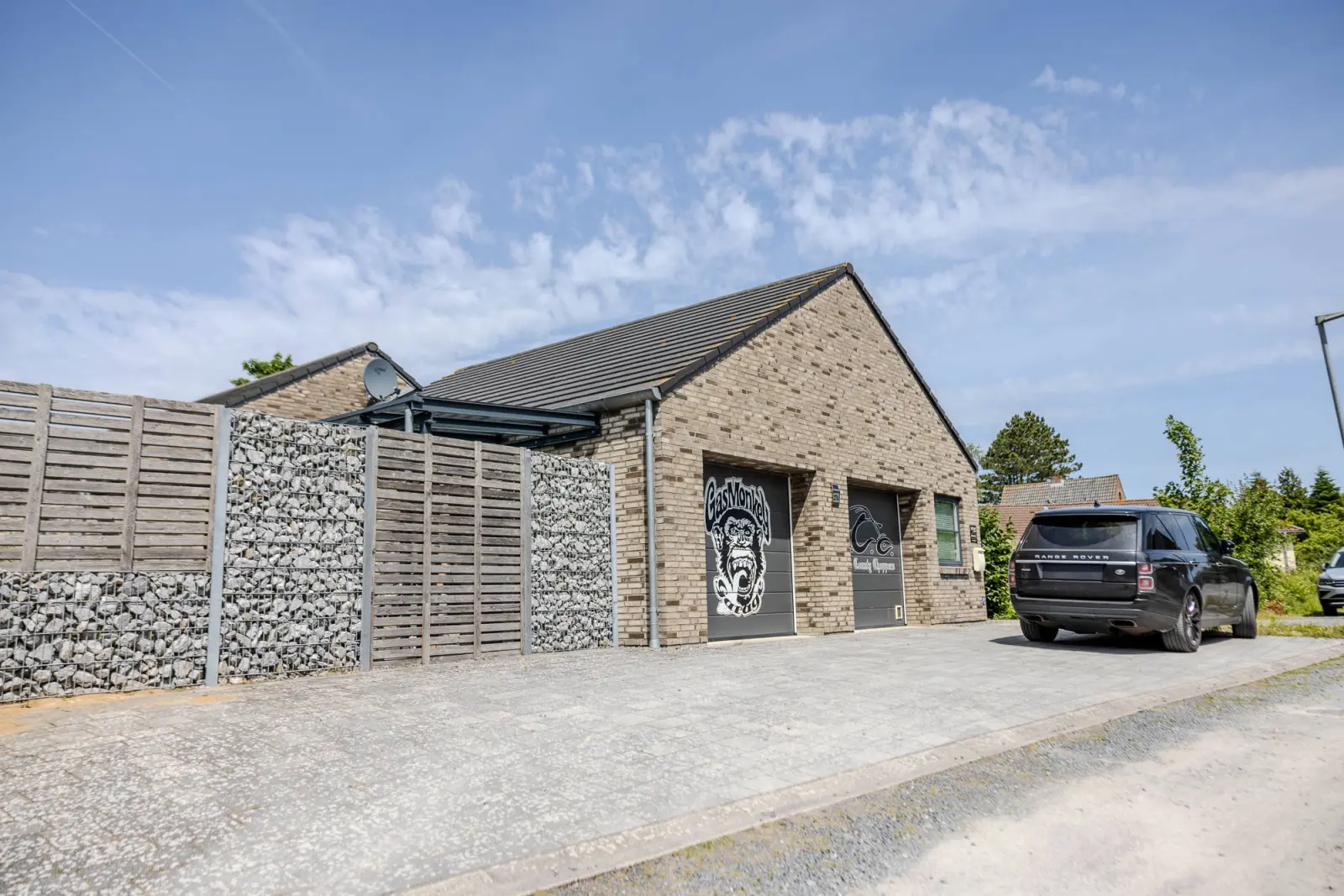Garagenseite des Skandinavischen Hauses mit Holz-Steinkorb-Sichtschutz