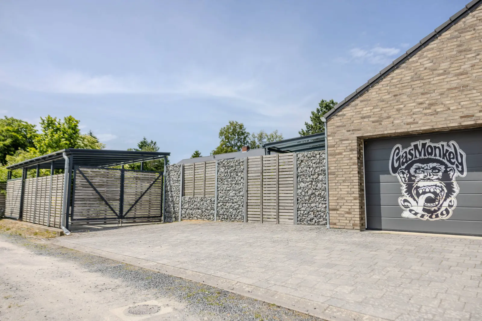Pflasterhof mit Carport-Tor, Sichtschutzwand und Garagentor mit Motiv