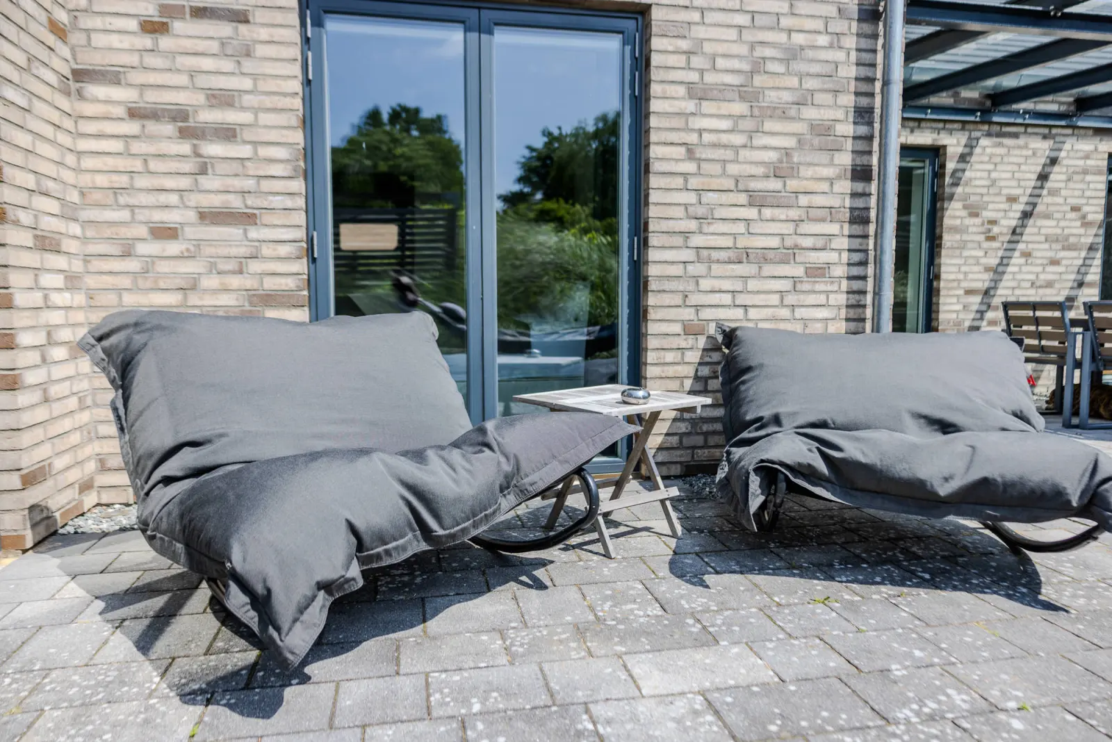 Zwei Sitzsack-Sessel mit grauem Bezug vor bodentiefen Terrassentüren