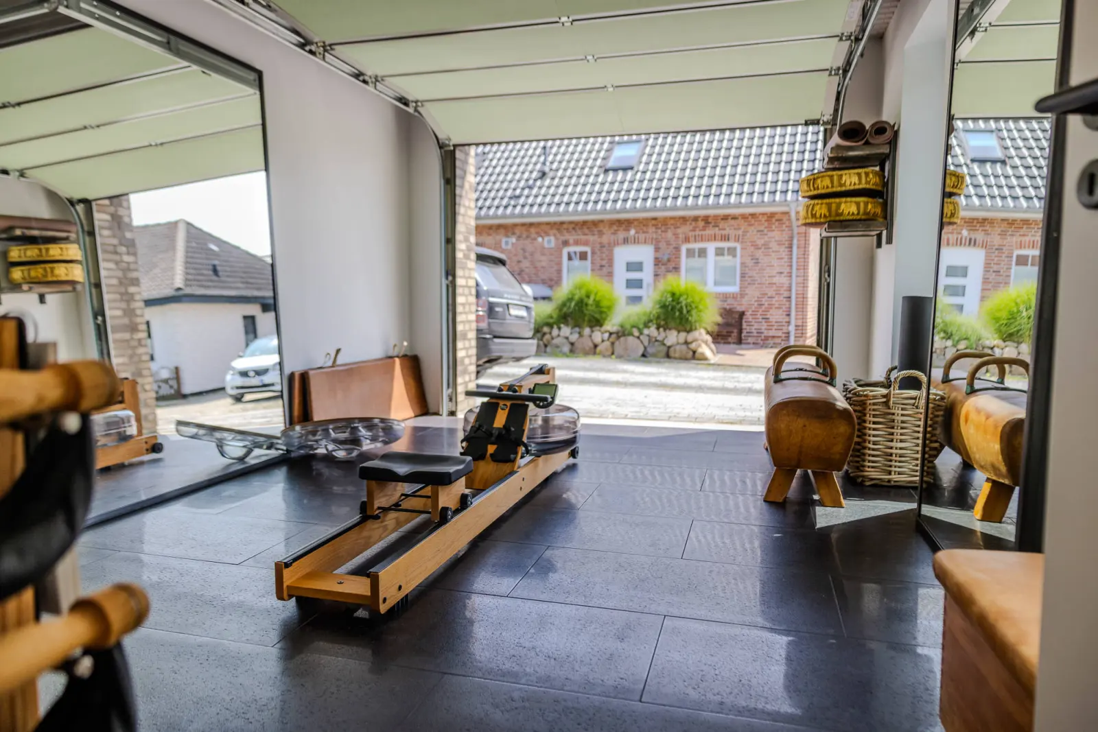 Holz-Rudergerät und Turnbock im Fitnessraum, Tor zur Straße geöffnet