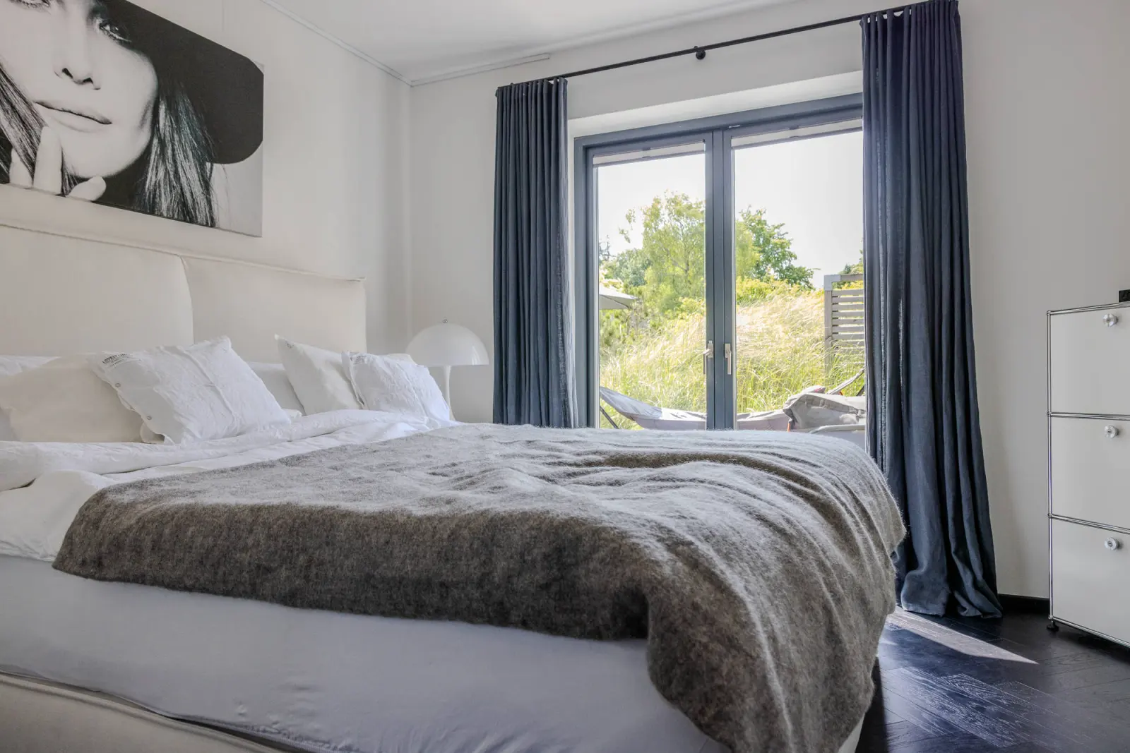 Schlafzimmer mit Doppelbett, grauer Decke und Terrassentür