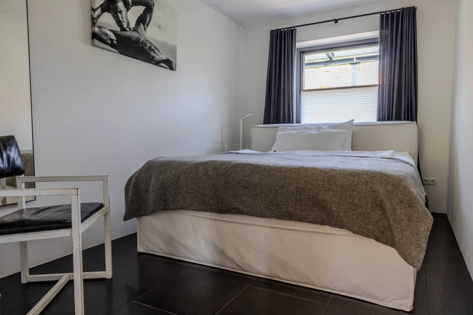 Kleines Schlafzimmer mit Doppelbett, Spiegel und Stuhl