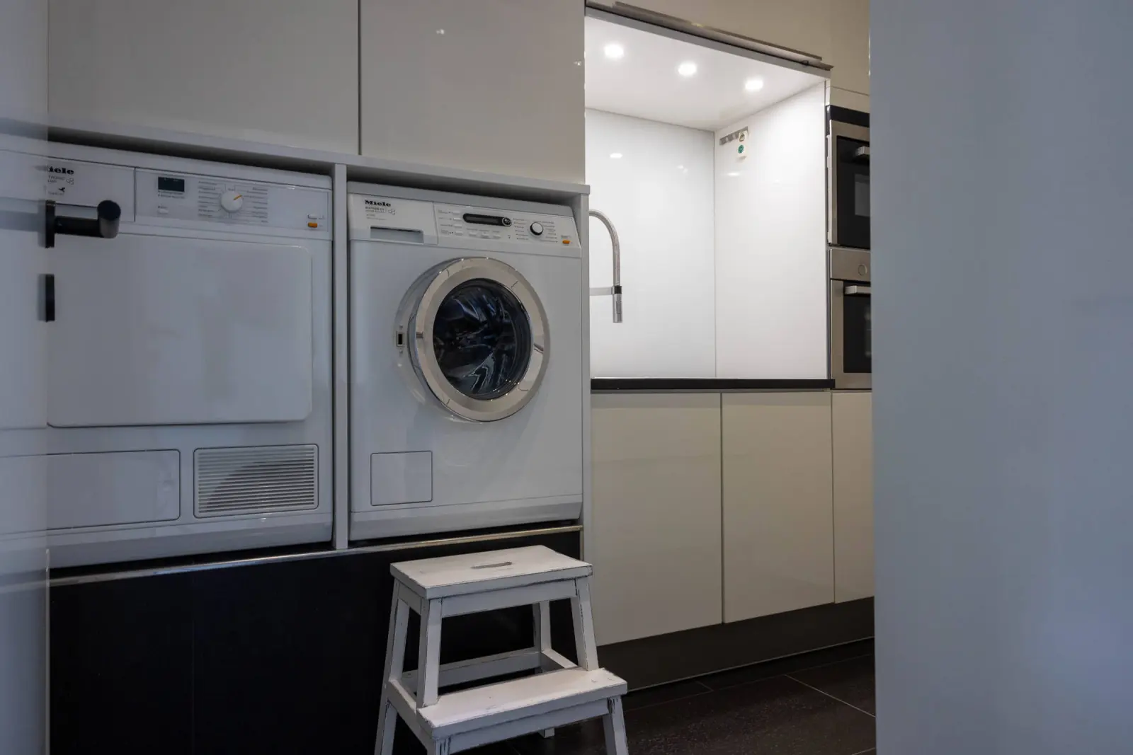 Hauswirtschaftsraum mit Waschmaschine, Trockner und Trittleiter