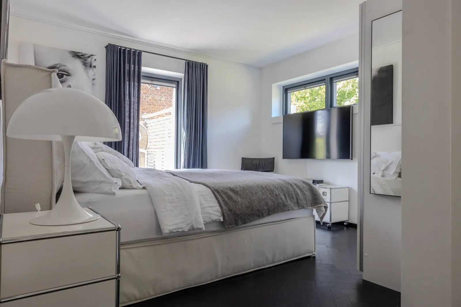 Schlafzimmer mit Doppelbett, Pilzlampe, Wand-TV und Standspiegel