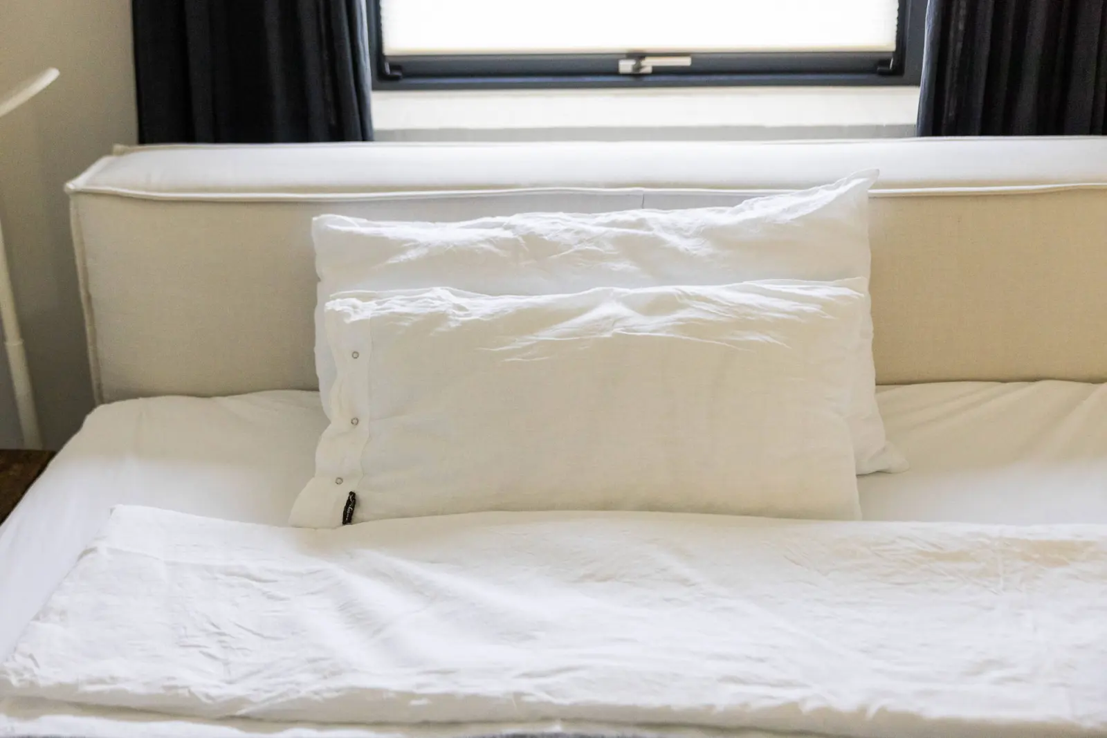 Bett mit weißen Kissen und Bettwäsche, Detailaufnahme
