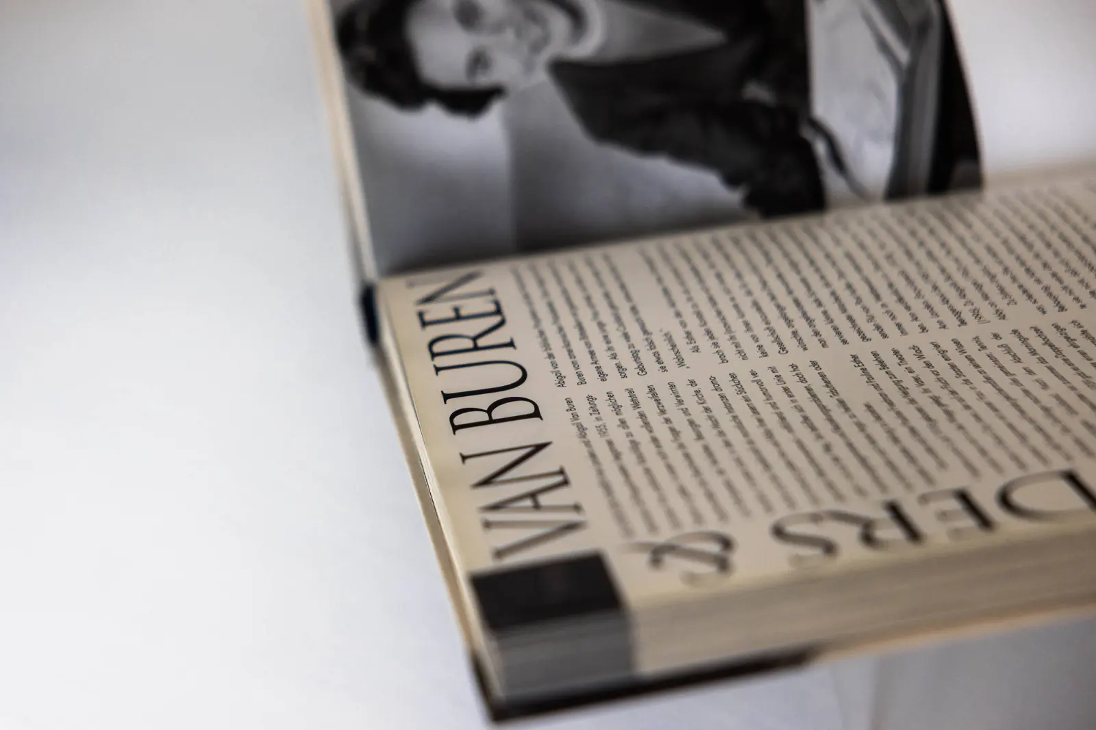 Aufgeschlagenes Buch mit Schwarz-Weiß-Foto auf weißer Fläche