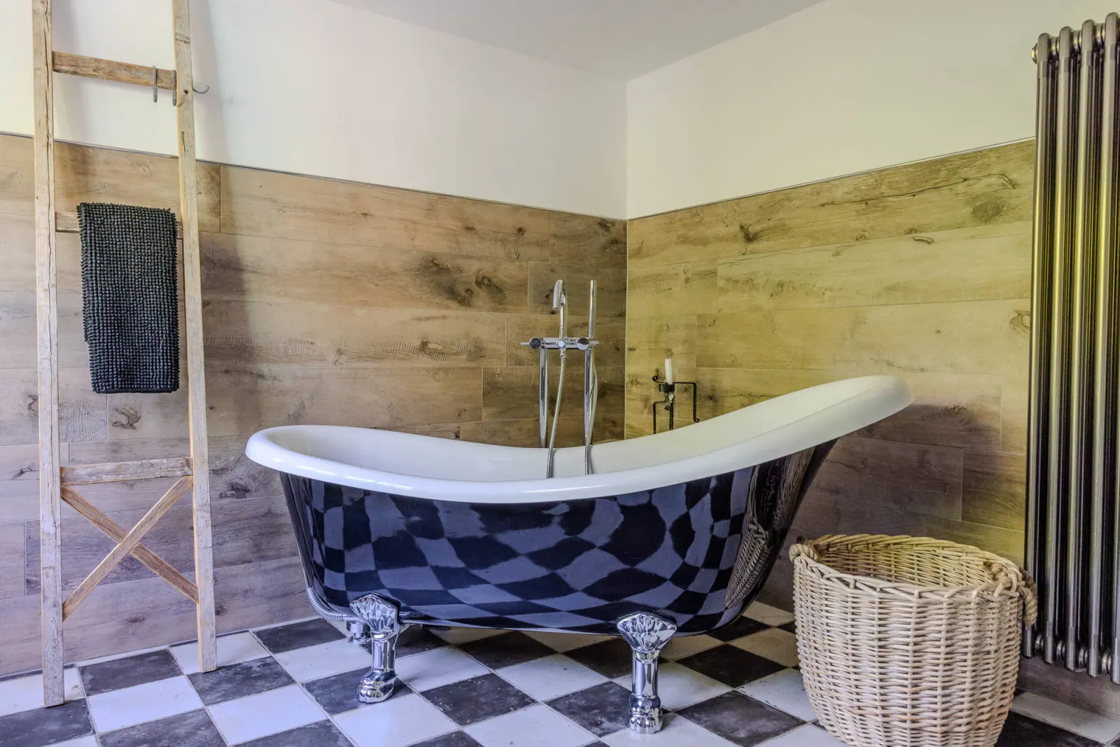 Bad mit freistehender Wanne auf Löwenfüßen, Holzverkleidung und Handtuchleiter