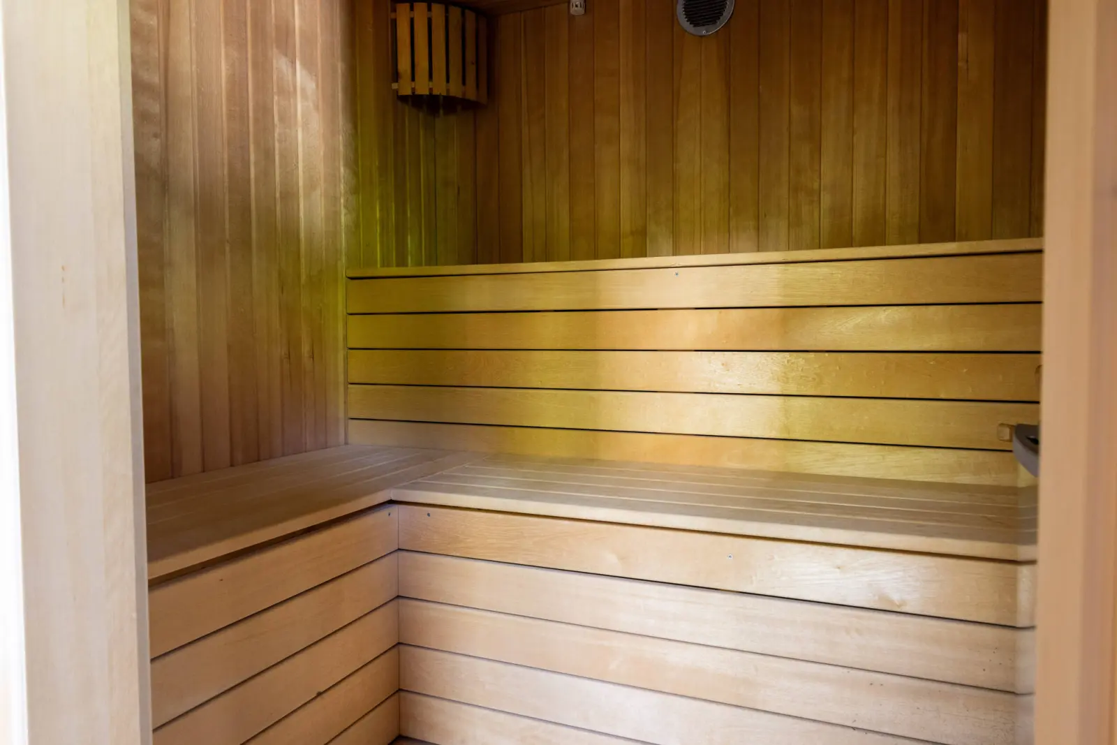 Saunakabine aus hellem Holz mit umlaufender Sitzbank im Stadthaus