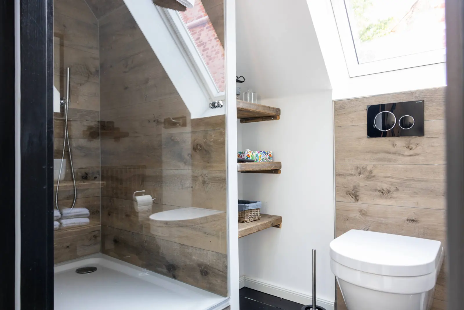 Duschbad mit Holzverkleidung, Dachfenster und Wand-WC