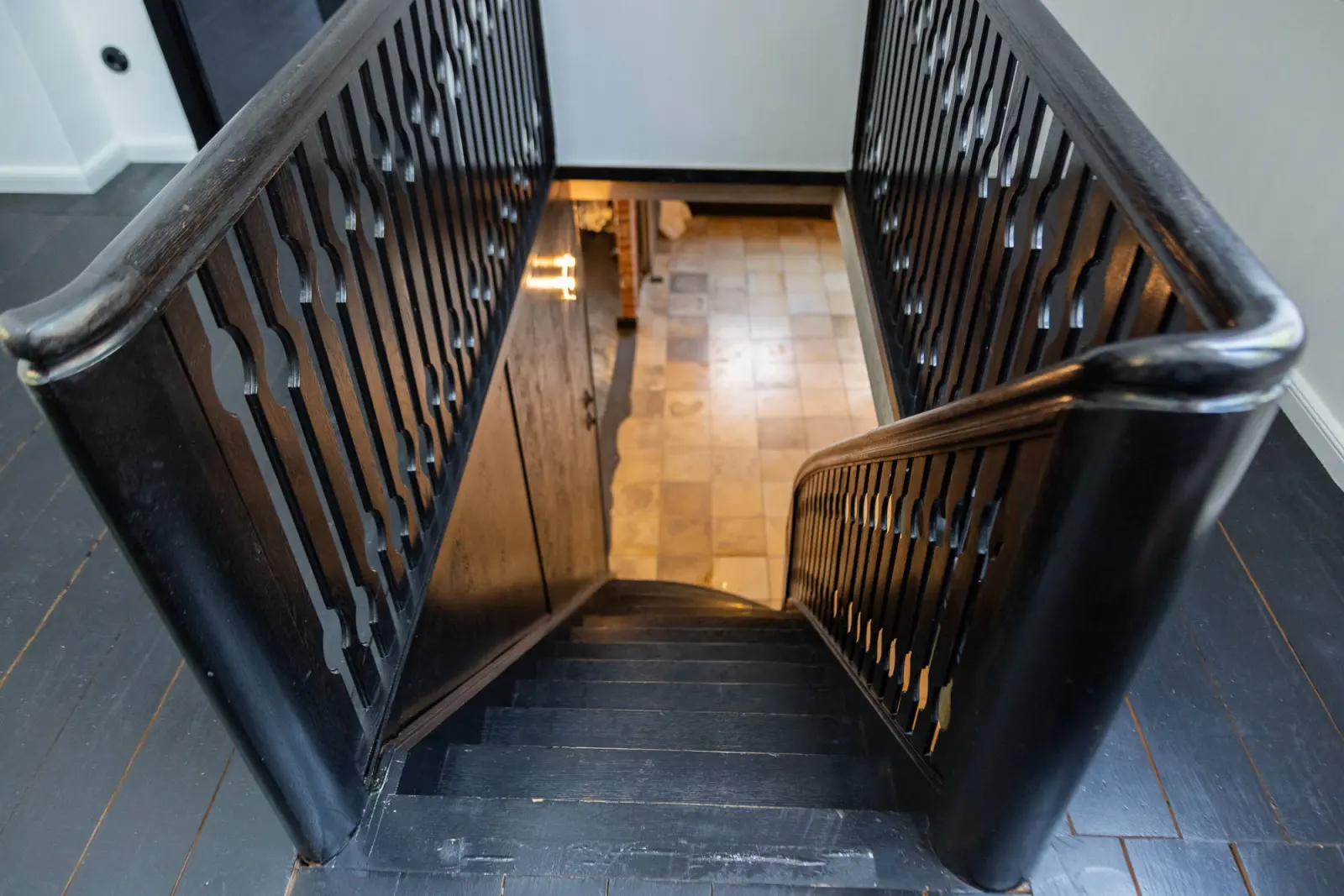 Blick von oben in das Treppenhaus mit schwarzem Geländer
