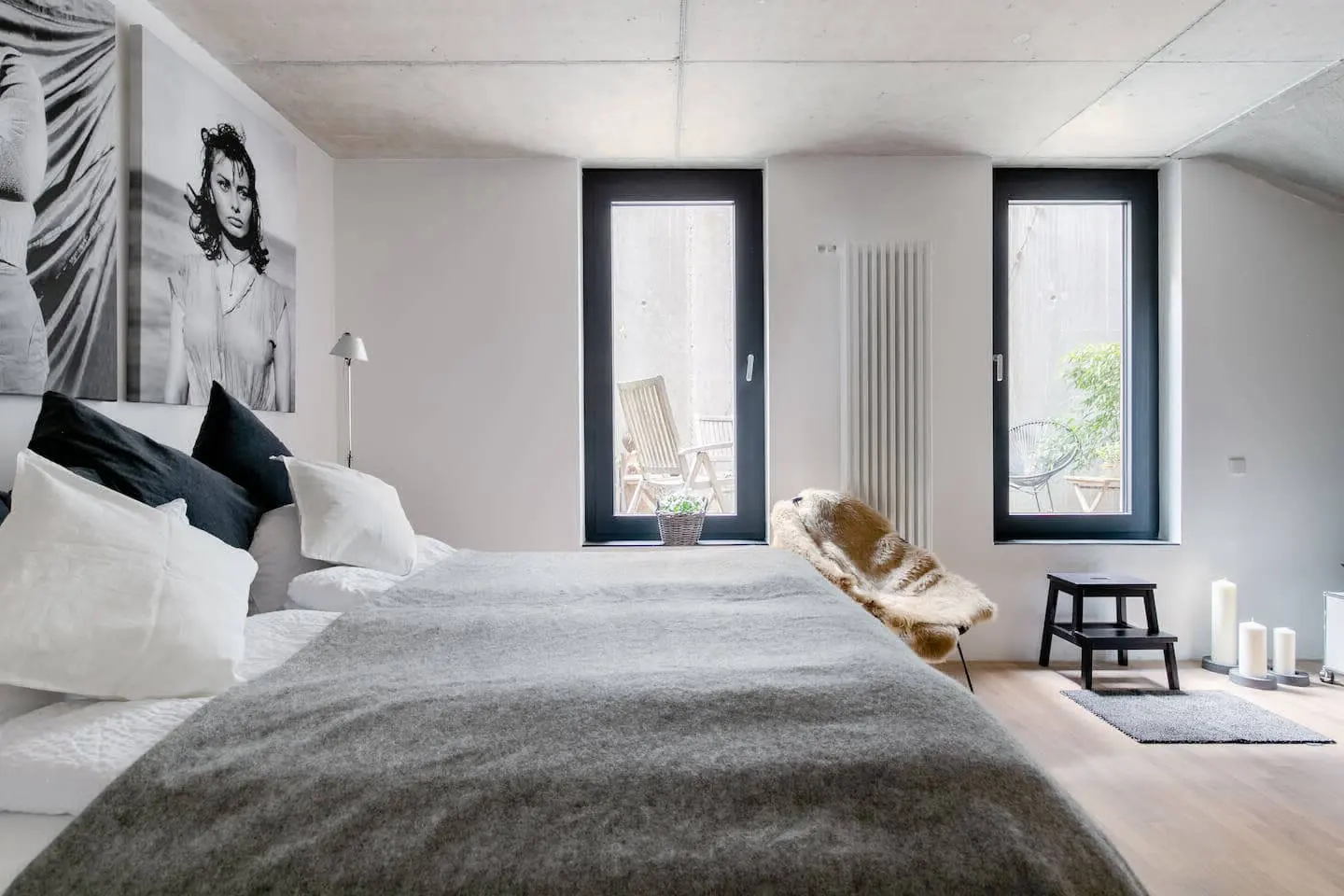 Doppelbett mit grünem Rahmen, Wandschmuck und Durchblick zum Bad