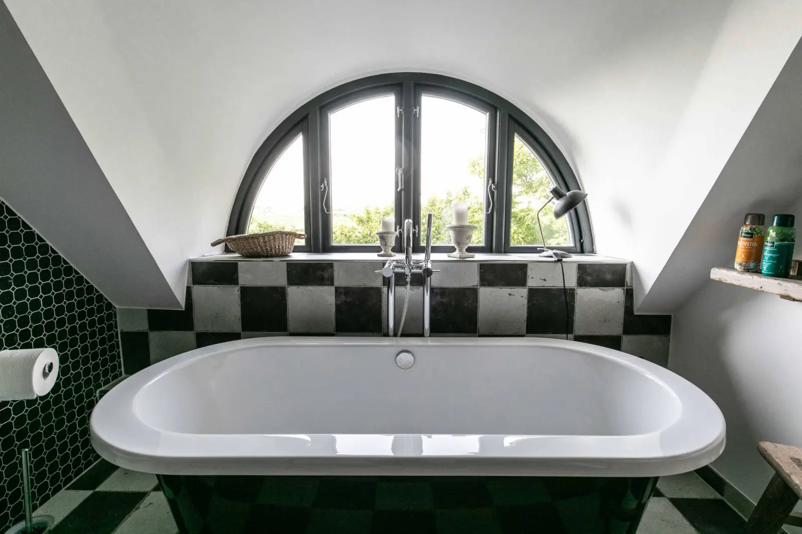 Freistehende Badewanne unter dem Halbrundfenster, Schachbrettfliesen im Bad
